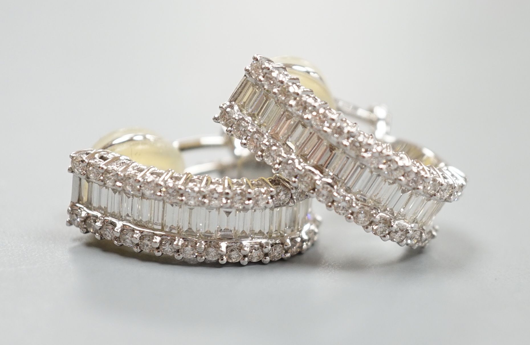 A modern pair of 18k white metal and three row baguette and diamond chip set shaped half hoop earrings, 20mm, gross weight 9.2 grams